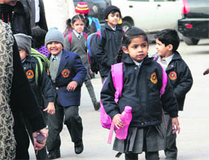 Small children brave the severe cold while going to their schools in Jalandhar on Tuesday. 