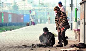 Children keep themselves warm by burning a bonfire at the platform of Ludhiana railway station.