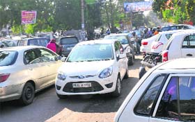 Traffic snarl: Vehicles parked in a haphazard manner alongside the road at the scooter market in Mohali on Wednesday