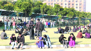 University students bask in the sun in Jalandhar on Wednesday.