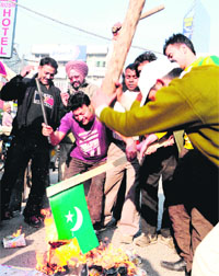 Shopkeepers burn Pakistans flag to protest against the brutal killing of Indian Army jawans by Pakistani forces, in Amritsar on Thursday.