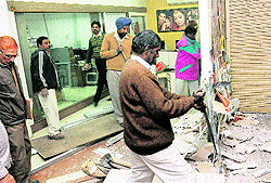 Enforcement staff of the UT estate office remove a partition from a shop in Sector 22 in Chandigarh on Thursday