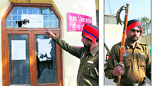 A policeman shows damaged windowpanes at the police station; and (right) arms seized from the attackers