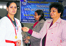 The principal of DAV College, Yamunanagar, awards a gold medal to the winner of a taekwondo competition