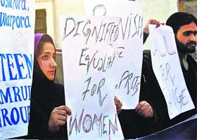 Students hold banners and placards during a protest against acid attack in Srinagar on Thursday