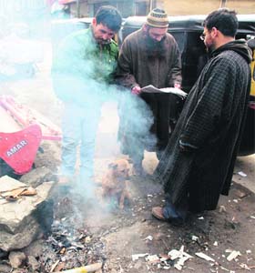 A puppy makes the most of a bonfire in Srinagar on Thursday