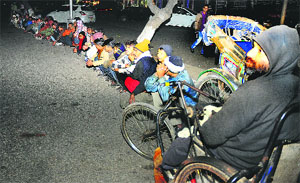 Rickshaw-pullers and other poor people wait in the cold.