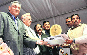 Chief Minister Vijay Bahuguna honours a handicrafts artisan at the conclusion of the National Handloom Expo at Parade Ground in Dehradun on Friday. 