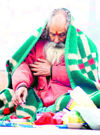 A sadhu performs rituals on a Ganga ghat during a chilly and foggy day in Haridwar on Friday.