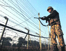 A BSF soldier patrols near the fenced border with Pakistan in the Jammu region on Friday. 