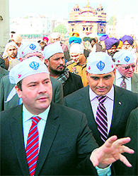 Members of the Canadian Backloggers Association show black flags to Canadian Minister of Citizenship, Immigration and Multiculturalism Jason Kenney (left) to protest against the delay in the processing of their visa applications, near the Golden Temple in Amritsar on Friday