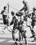 Soldiers catch a youth, who tries to enter the enclosure of selected candidates after failing the physical test, at the recuritment rally in Ludhiana on Friday