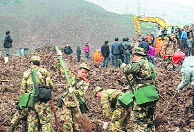 Paramilitary policemen search for survivors after a landslide hit Zhenxiong county in China on Friday. 