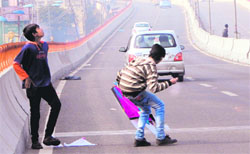 Playing with danger: Boys grab kites on the elevated road in Amritsar on Saturday. Photos: Vishal Kumar