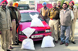 The Dehlon police with seized bags of poppy husk and the car used for supplying them on Saturday
