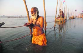 Faith calls: A devotee prays before taking a dip in the holy Ganges in Allahabad ahead of the Mahakumbh, which begins on Monday