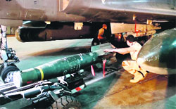A video grab shows soldiers at the French military base of N'Djamena, in Chad, as they load a missile onto a French Mirage 2000 D aircraft before flying over Mali on Saturday. AFP