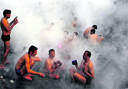 Devotees take a dip in a hot water spring on the occasion of Makar Sankranti at Tattapani in Mandi district on Sunday
