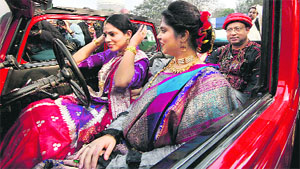 A lady adjusts her hair as she sits in a 1938 Alder car during a vintage car rally in Kolkata on Sunday.