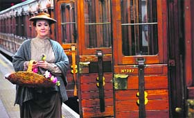 An actress poses next to a steam train which used to carry passengers in the 19th century as it arrived at Moorgate Underground Station in central London on Sunday to mark 150 years since its first underground journey.