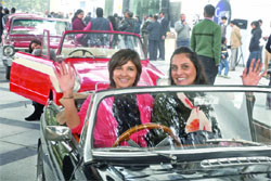 Women pose with their vintage cars as they participate in Women Vintage Car Rally in New Delhi on Monday. Tribune photo: Manas Ranjan Bhui