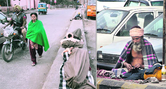 The destitute make a road divider outside the city railway station their home in Jalandhar on Monday.