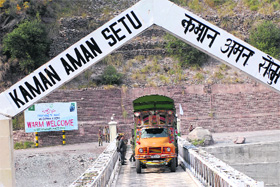 Trucks from Muzaffarabad (PoK) cross the LoC at Kaman Post in Uri on Monday.