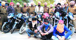Three accused (with covered faces) in the police custody. The police seized eight motorcycles, intoxicants and a mobile phone from the trio in Jalandhar on Tuesday. Photo: Sameer Sehgal 