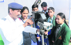 A traffic policeman explains the working of a laser speed gun to students at Sector 23 in Chandigarh on Tuesday. 