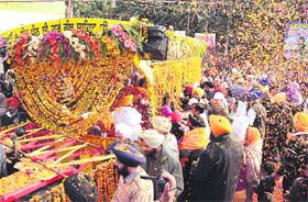 Pilgrims progress: Devotees shower flower petals on the palanquin during the nagar kirtan being taken out to mark the forthcoming Gurpurb in Jalandhar on Tuesday
