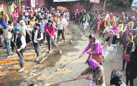 Gurpurb celebrations Devotees use brooms to clean the road for the nagar kirtan being taken out to mark the forthcoming birth anniversary of Guru Gobind Singh