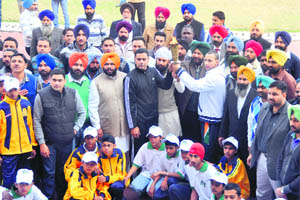 Athletes hold the torch during the opening ceremony of the Jarkhar Sports Festival in Ludhiana on Tuesday.
