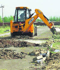 A JCB machine of GLADA dismantles roads in an illegal colony in Ludhiana. 