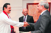 Sri Lankan President Mahinda Rajapaksa (L) shakes hands with Mohan Peiris (R) in Colombo on Tuesday.  AFP