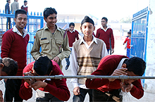 Students drink water at a tap in the stadium