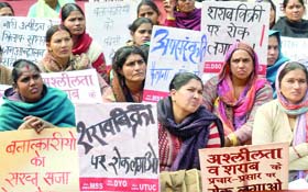 Demonstrators hold placards as they protest against the brutal gangrape at Jantar Mantar in New Delhi on Wednesday