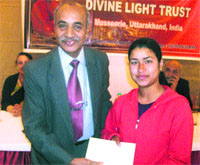 Director, ITM, RB Singh, gives a schoalrship to a student in Mussoorie