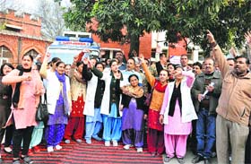 Nurses and other employees of the Civil Hospital protest against the hospital administration in Karnal on Wednesday