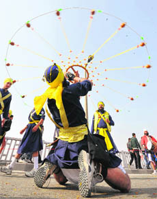A man exhibits martial art during nagar kirtan in Jammu on Wednesday. 