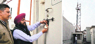 Assistant Town Planner Rajinder Sharma (left) gets a mobile tower (right) sealed near Guru Teg Bahadur Hospital in Ludhiana on Wednesday. Photos: Inderjeet Verma