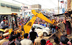A JCB machine demolishes illegal structures alongside the Kasturba Road in Rajpura on Wednesday