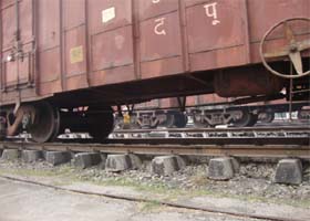 A woman is seen taking away the pilfered coal from underneath a wagon in the city