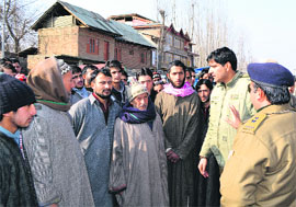 Policeman stops villagers who blocked a road in Bijbehara in Anantnag on Wednesday.