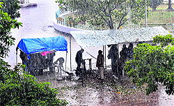 People take shelter in front of the district courts in Sector 1, as it rained heavily in Panchkula on Friday