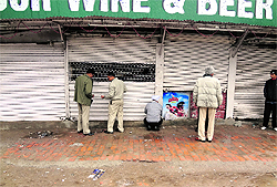 UT excise officials seal a liquor vend at Hallo Majra in Chandigarh on Friday