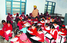 Class I to V students being taught in a room by a teacher at a government school at Saidpur Kalan. 