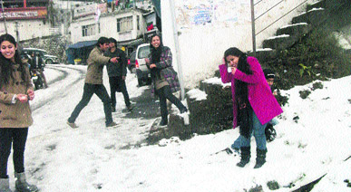 Tourists enjoy themselves after another spell of snow in Mussoorie on Saturday.
