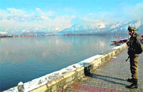 UNDER THE AZURE SKY: A CRPF jawan stands guard on the banks of the Dal Lake in Srinagar