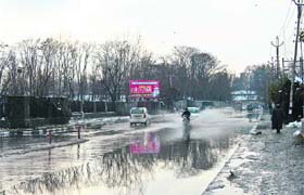 THROUGH SNOW-WATER: A motorcyclist wades through a waterlogged street in Srinagar