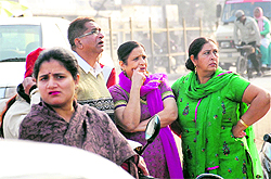 Residents, who had hired lockers at Punjab and Sind Bank, in a pensive mood outside the bank premises after the news of burglary spread at Reru village in Jalandhar on Saturday